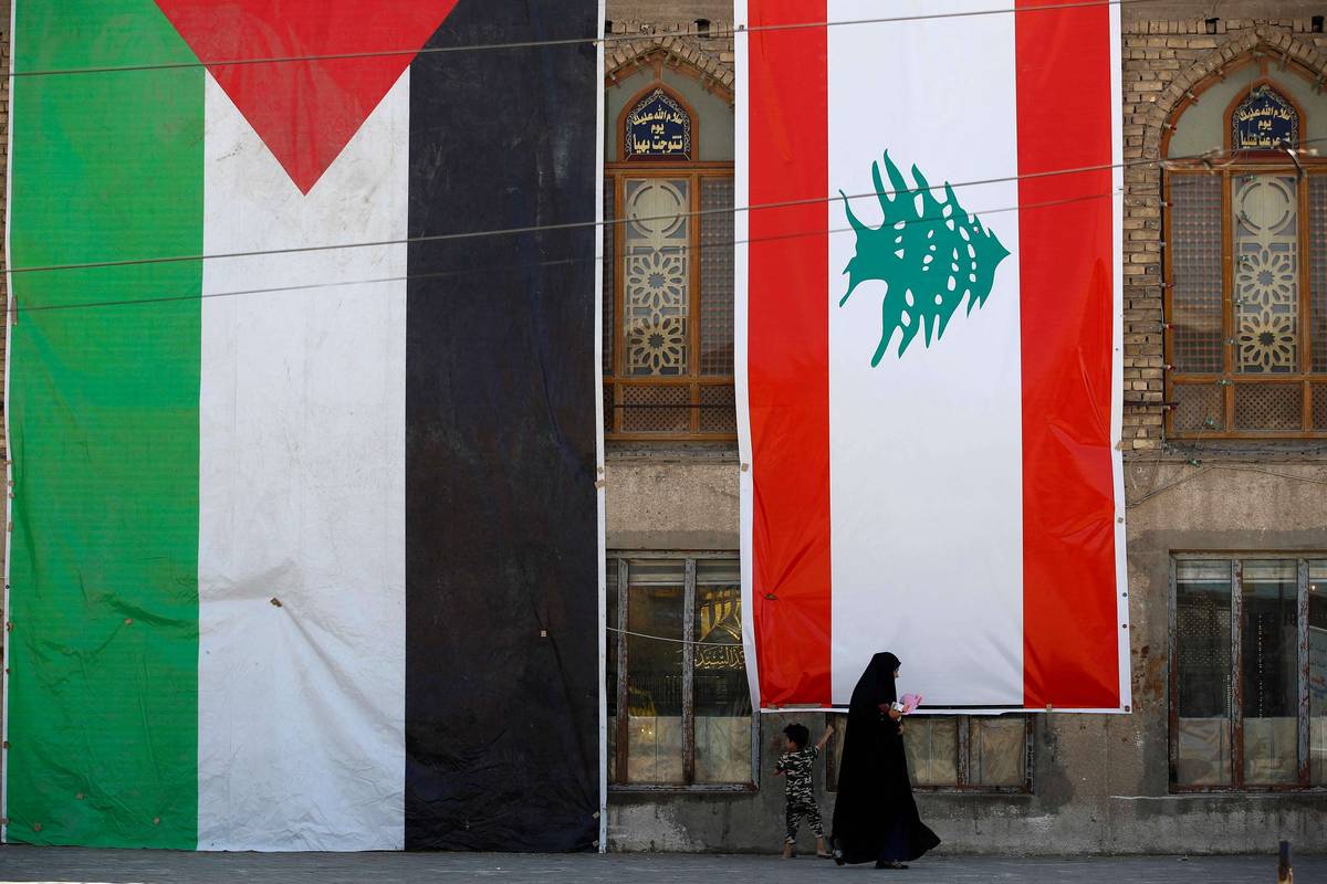 عراقيون أمام جامع يرفع اعلاما لفلسطين ولبنان