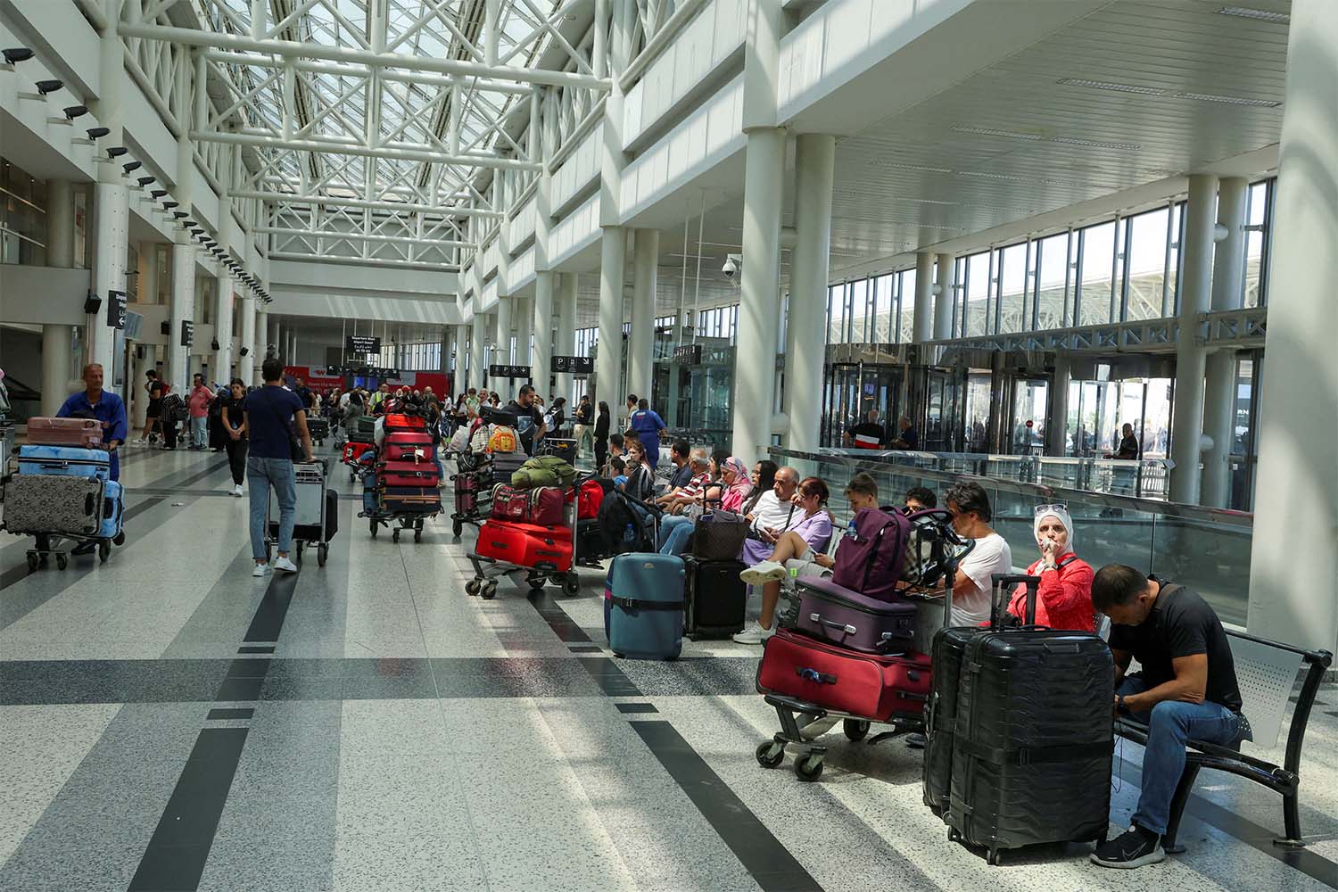 People wait with their luggage at Beirut-Rafiq Hariri International Airport