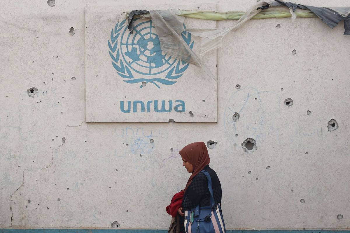 فلسطينية تمر بجانب مكتب الانروا في خان يونس