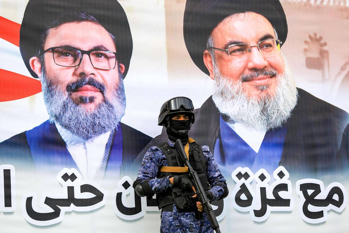 مقاتل حوثي أمام جدارية لحسن نصرالله وهاشم صفي الدين في صنعاء