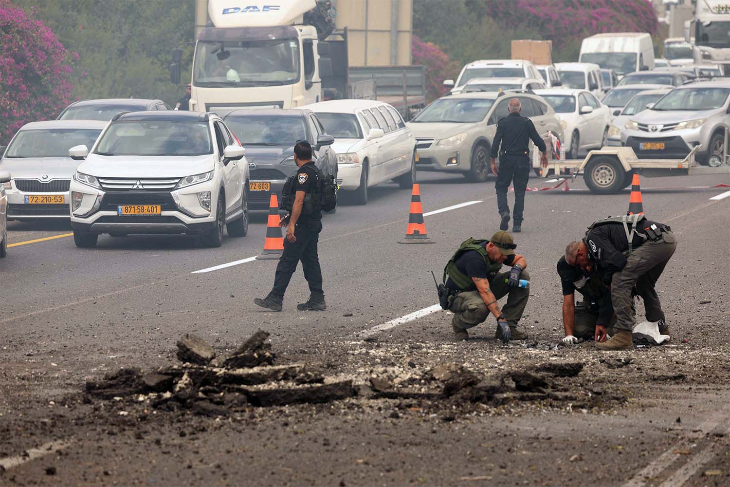 Members of Israeli security forces inspect the impact site of a reported rocket fired from Lebanon on central Israel