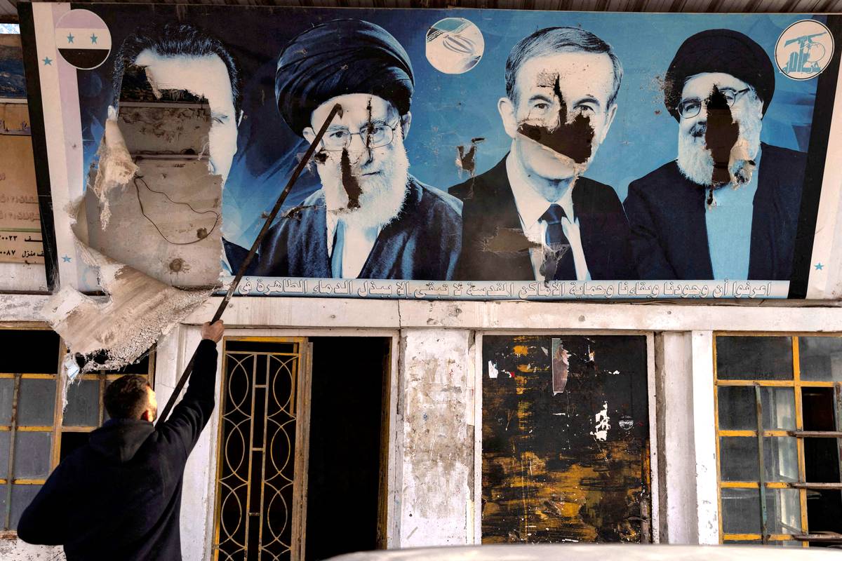 جدارية محطمة للرئيسين السوريين السابقين حافظ الأسد وبشار الأسد وزعيم حزب الله السابق حسن نصرالله والمرشد الإيراني الأعلى علي خامنئي في قرية بالقرب من حلب