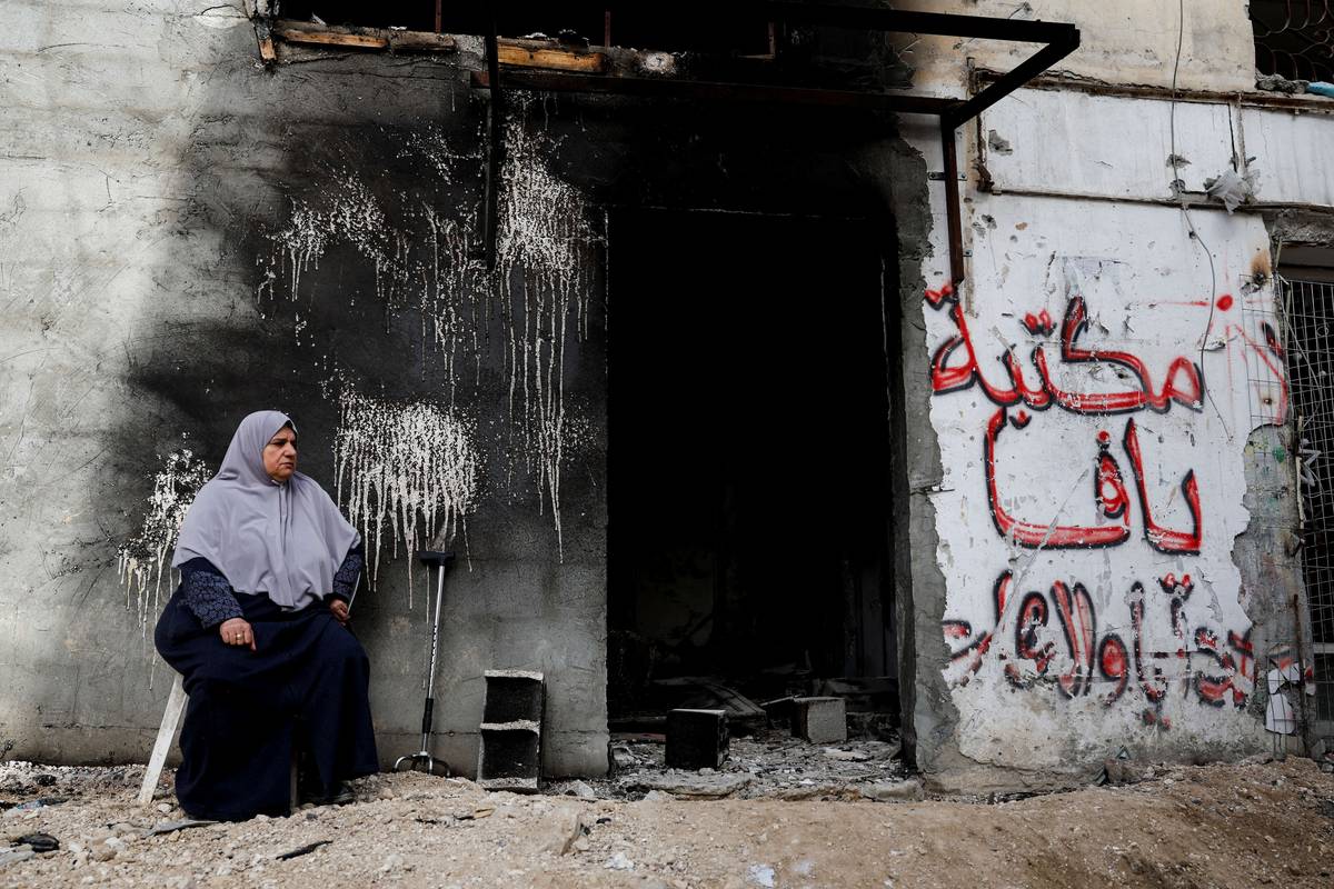 فلسطينية في طولكرم بجانب محل مدمر