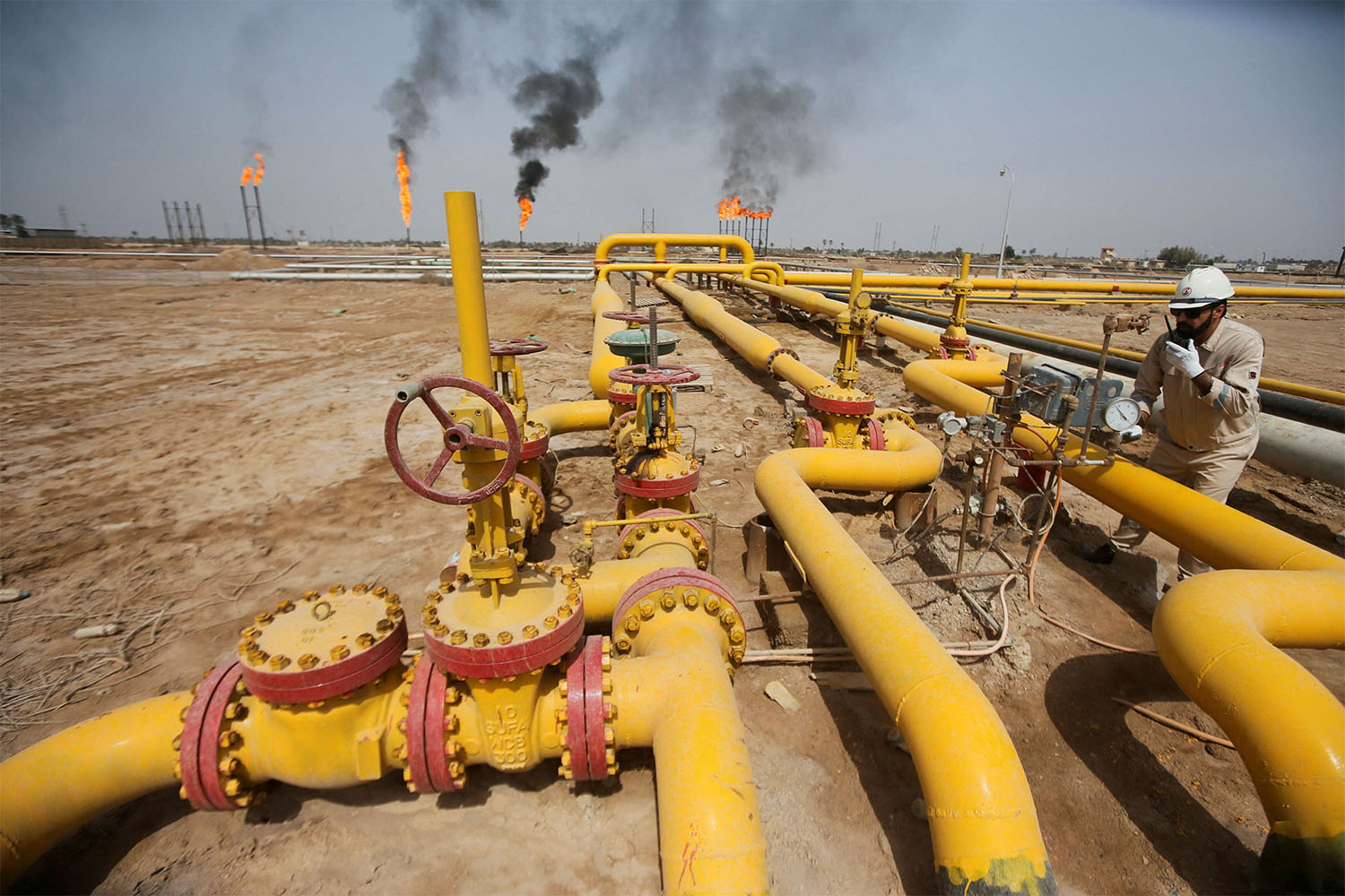 A worker checks an oil pipeline at Nahr Bin Umar oil field, north of Basra