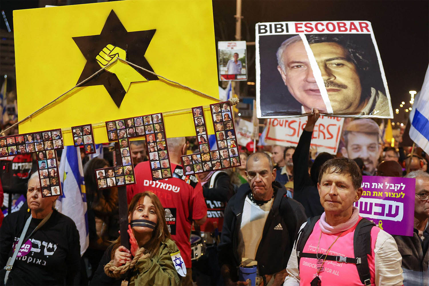 Protesters hold placards and wave flags during a demonstration calling for the release of hostages held captive in Gaza 