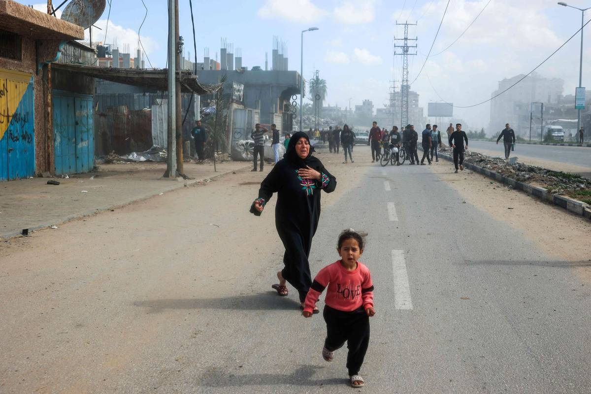 طفلة فلسطينية وأمها تفران من منطقة القصف الإسرائيلي في مخيم النصيرات وسط غزة