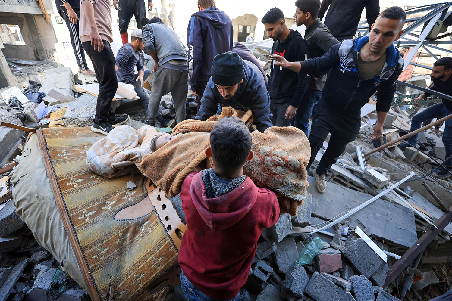 A man carries the body of a Palestinian child killed in an Israeli airstrike on Gaza