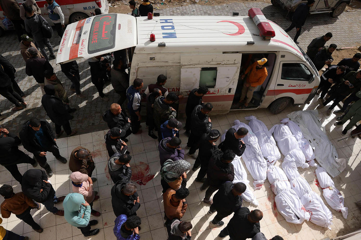 Palestinians recite a prayer over the bodies of victims of Israeli overnight airstrikes in the northern Gaza Strip