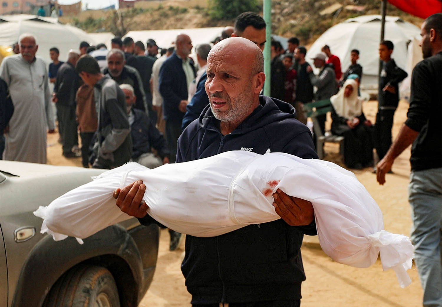 A man reacts holding the body of a Palestinian child killed in Israeli strikes on Gaza