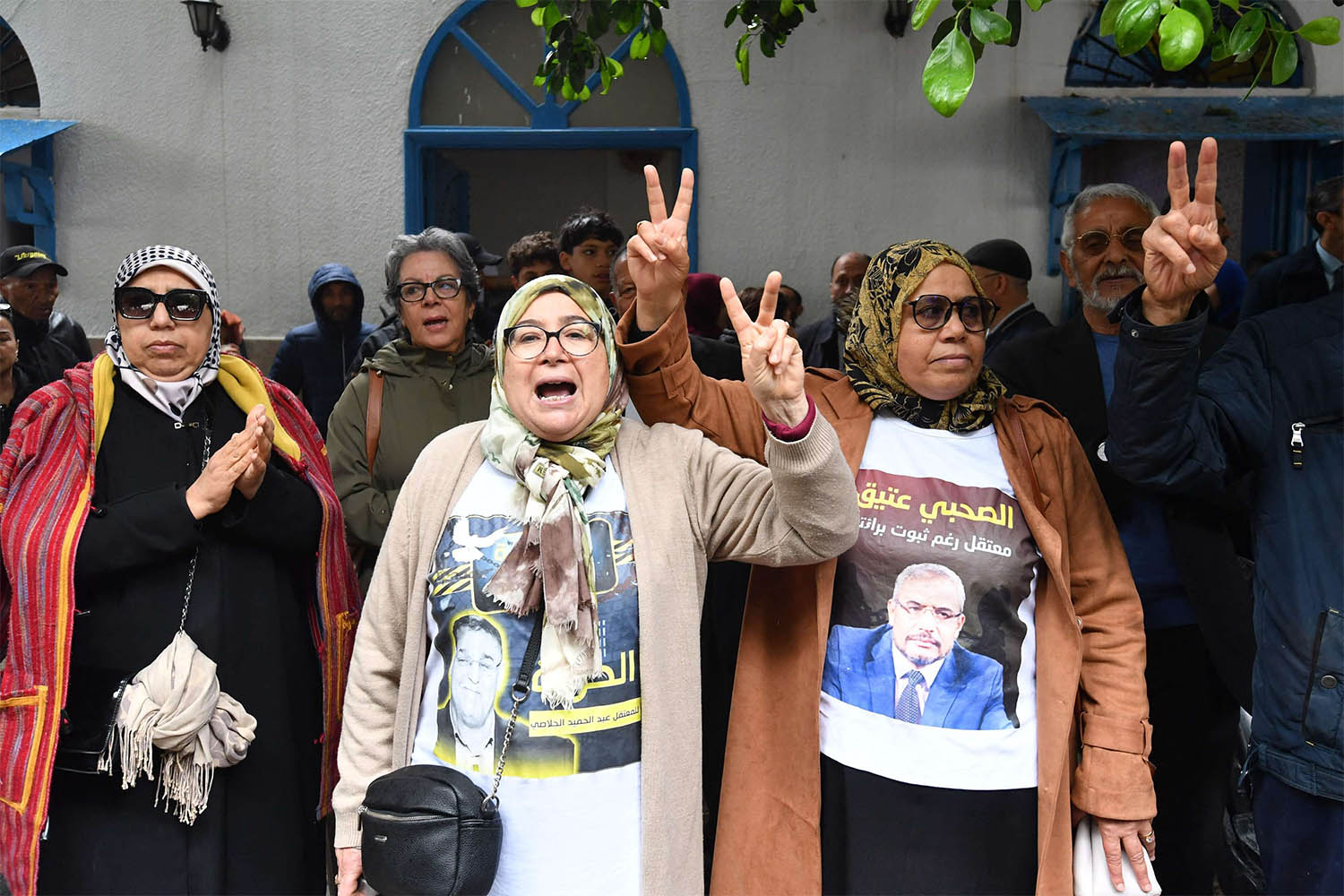 Families and relatives of the detained political opposition figures in the so-called conspiracy against state security case hold up photos of the detainees during a demonstration in front of the court in Tunis