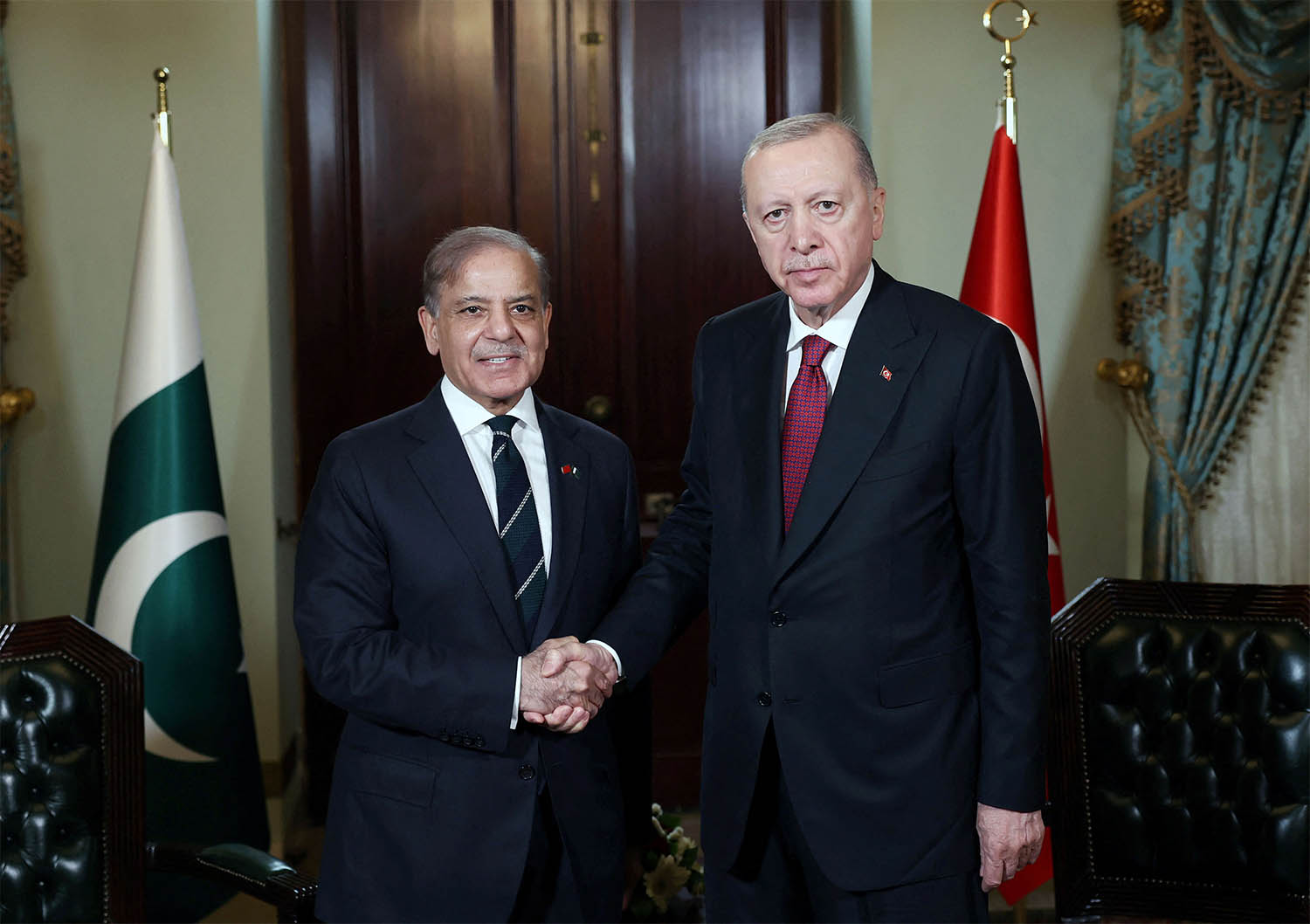 Turkey’s President Tayyip Erdogan shakes hands with Pakistan's Prime Minister Shehbaz Sharif before their meeting in Istanbul