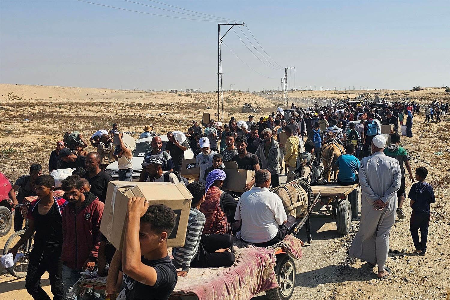 Displaced Palestinians walk along a road to receive humanitarian aid packages from a US-backed foundation in Rafah in the southern Gaza Strip on June 