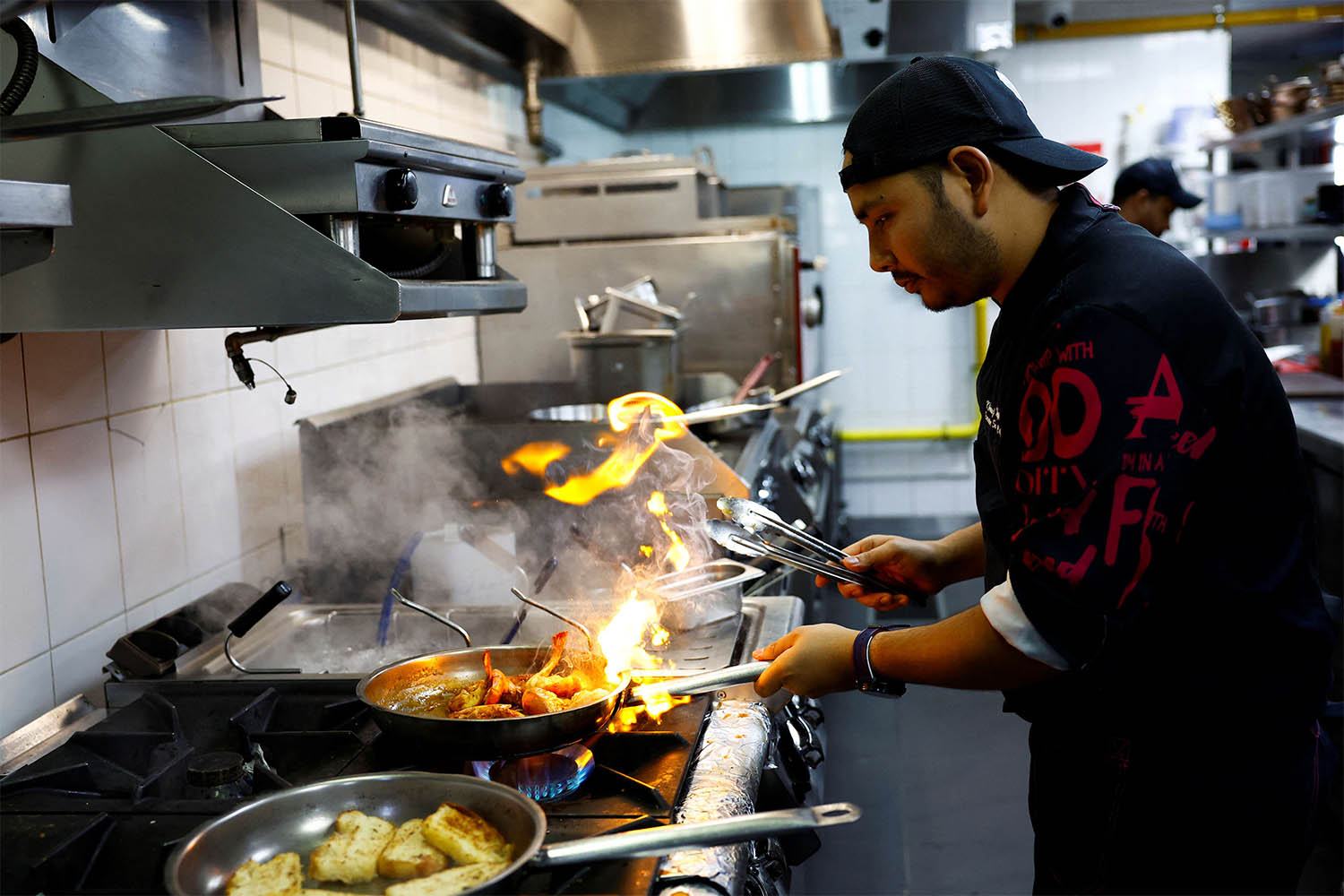 Chef Khimraj Nepali prepares a dish using the recipe from Aiman, the AI Chef