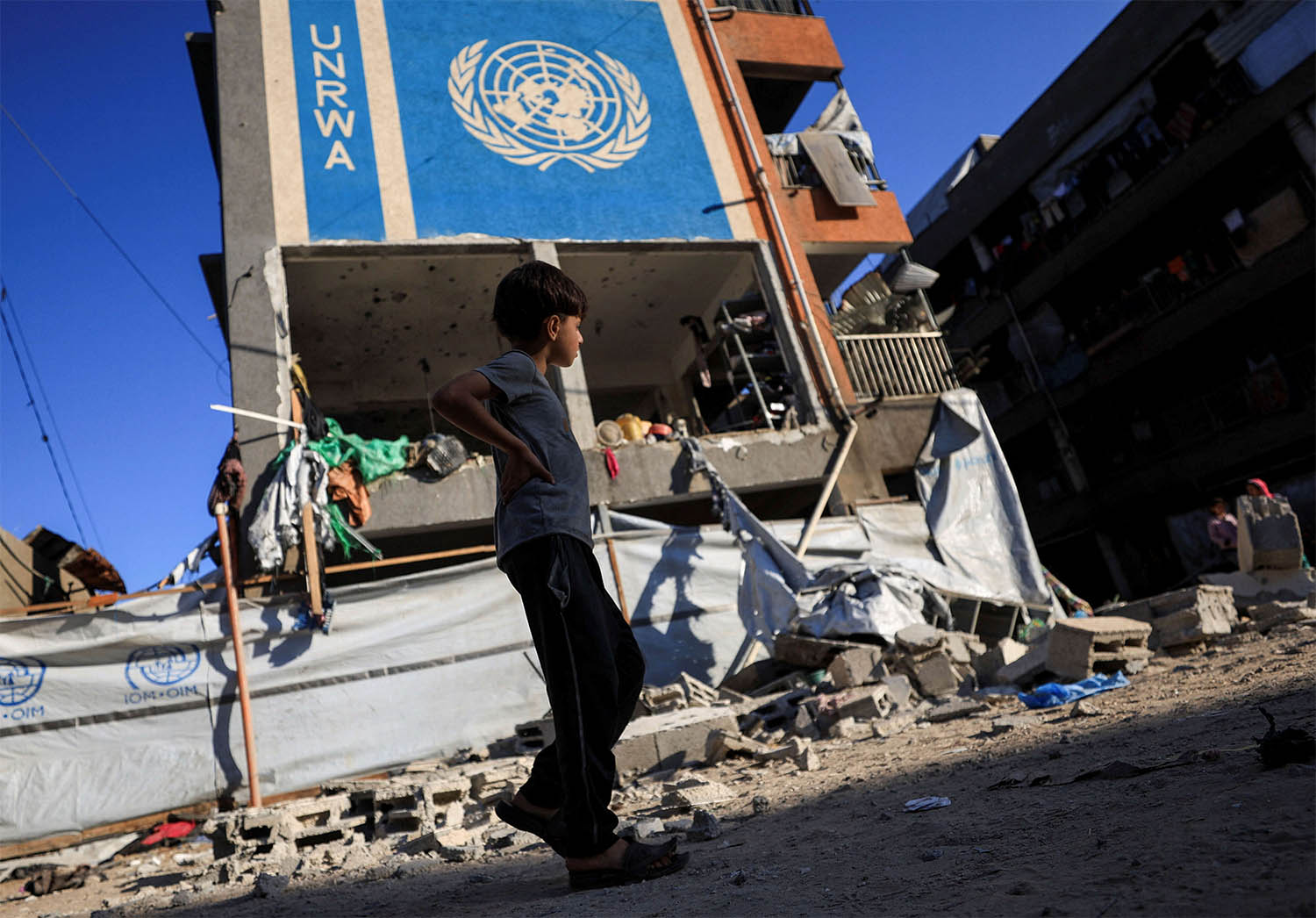 A Palestinian boy walks near an UNRWA school sheltering displaced people that was hit in an an overnight Israeli strike, in Gaza City, July 5