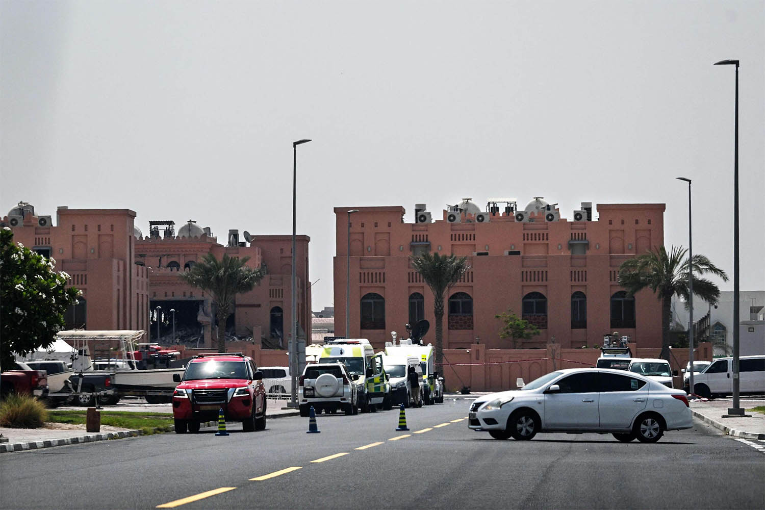 the damaged building (L) in The compound housing members of Hamas political bureau which was targeted the previous day by an Israeli strike in Doha