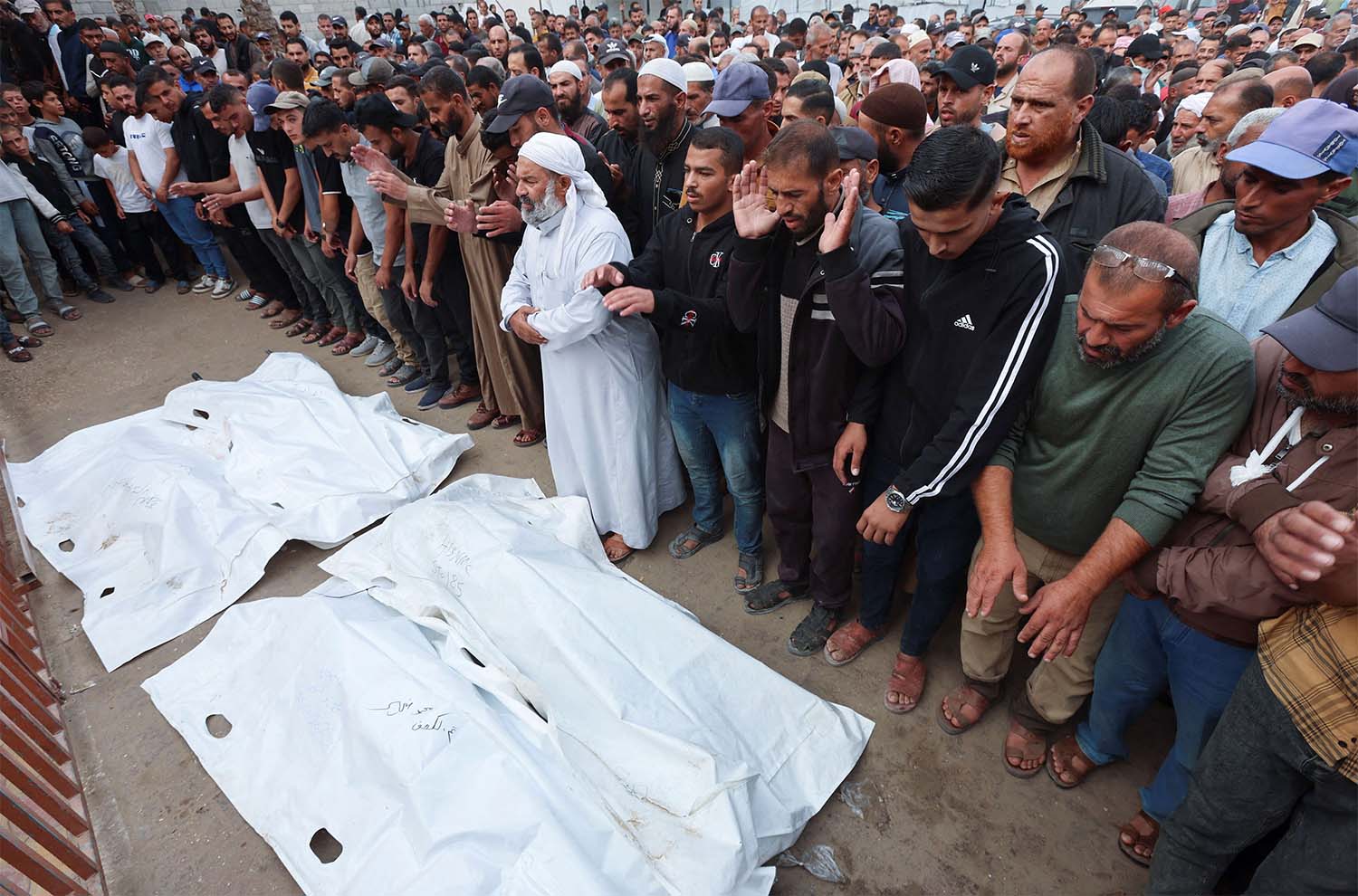 Mourners pray as they attend the funeral of Palestinians who were killed in overnight Israeli strikes in southern Gaza Strip
