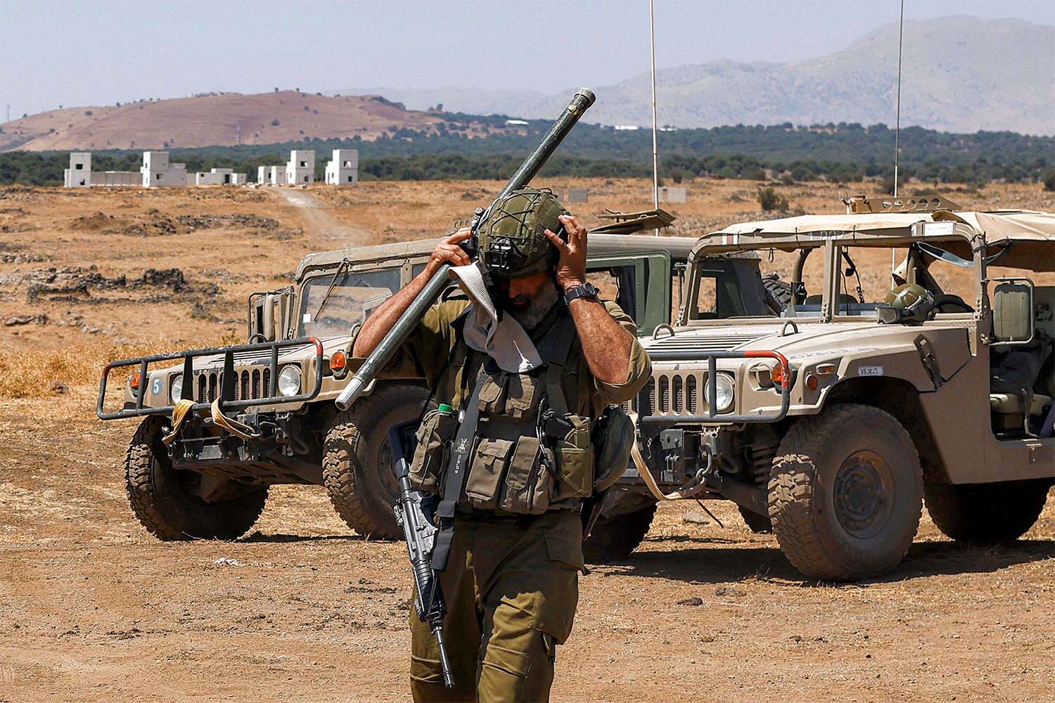 An Israeli army soldier adjusts his helmet 