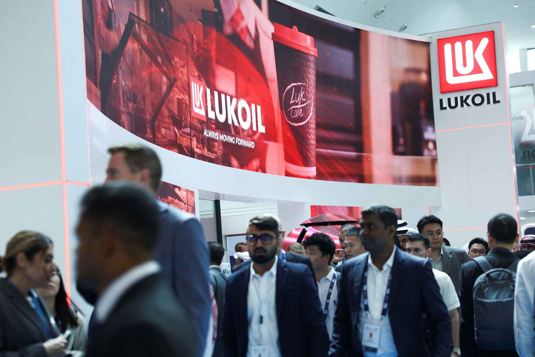 People walk past the booth of Lukoil during the annual energy industry event Abu Dhabi International Petroleum Exhibition and Conference (ADIPEC) in Abu Dhabi, November 3, 2025. 