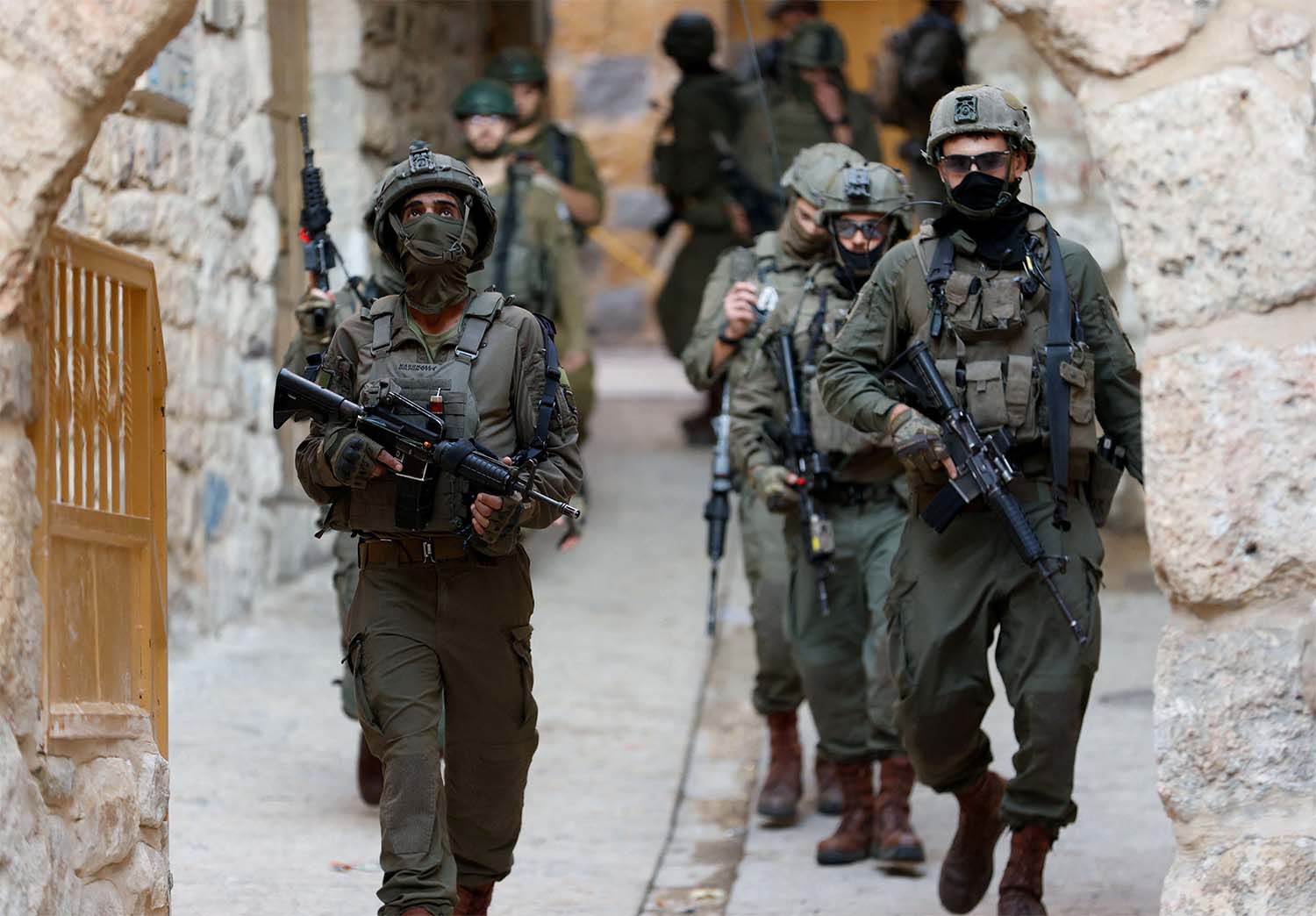 Israeli soldiers walk during a weekly settlers tour in Hebron