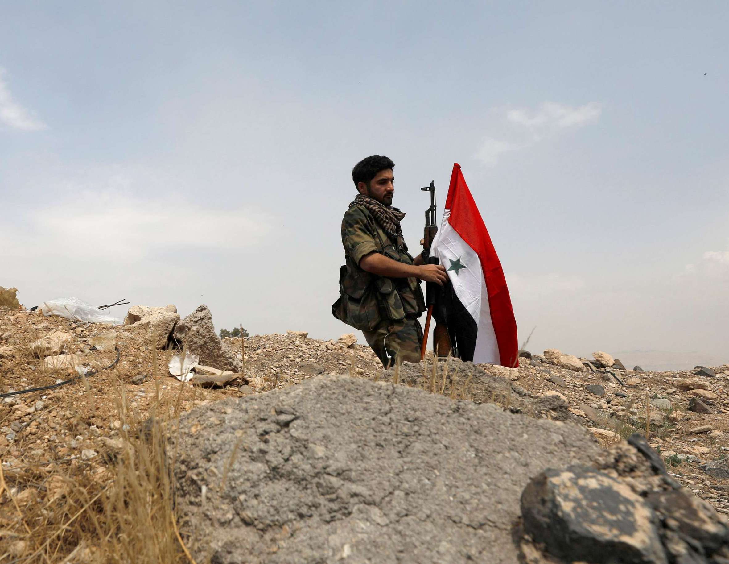 جندي سوري يحمل علم البلاد