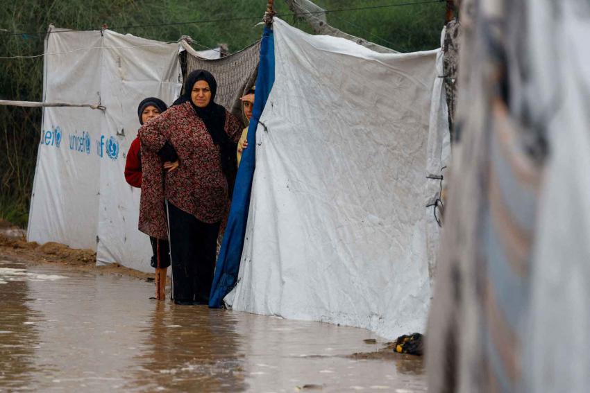Displaced Palestinians shelter in a flooded tent camp on a rainy day in Nuseirat, central Gaza Strip, December 12, 2025.