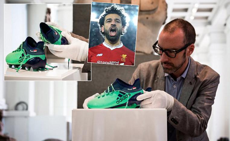 عامل بالمتحف البريطاني يضع حذاء محمد صلاح في مكانه