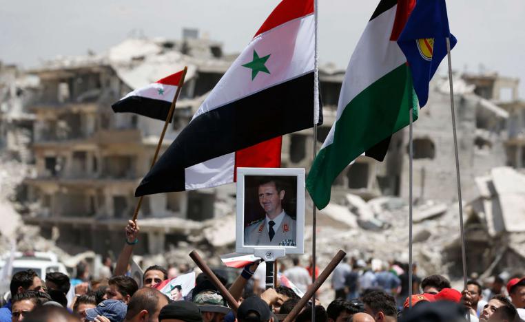 مقاتلون سوريون وفلسطينيون وإيرانيون يحتفلون بسقوط مخيم اليرموك