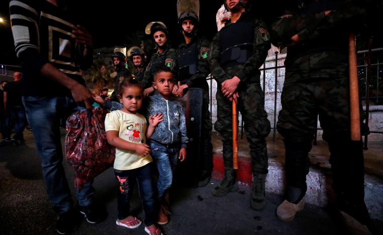أطفال فلسطينيون يمرون بجانب قوات الأمن في رام الله