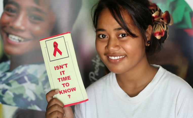 مراهقة تحمل مطبوعة توعوية ضد الايدز