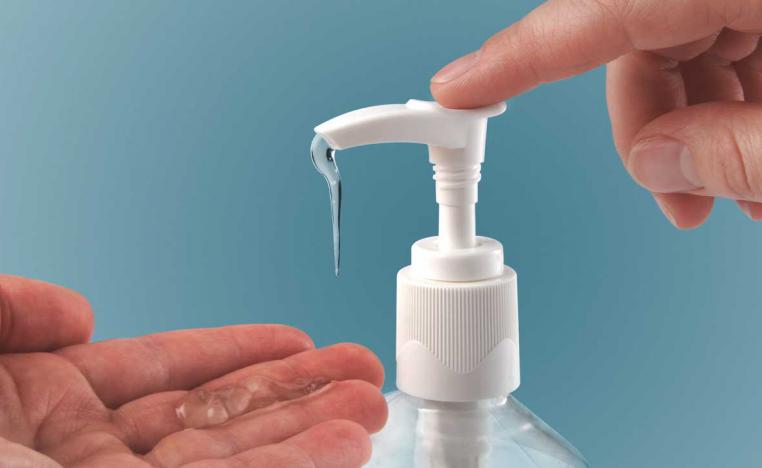 شخص يستخدم صابونا سائلا لتطهير يديه