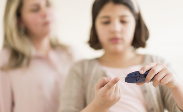 فتاة صغيرة تقيس  تحت انظار امها معدل السكري