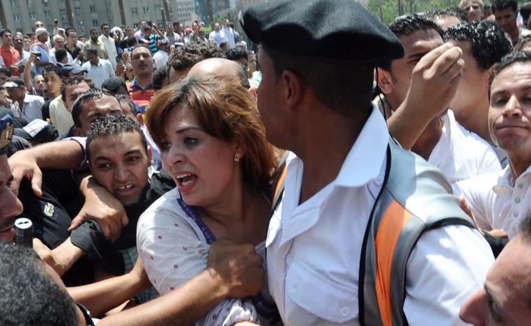 فتاة تحتمي بشرطي مصري وسط حشد غفير من الرجال