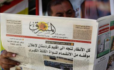 عراقي يتصفح صحيفة محلية