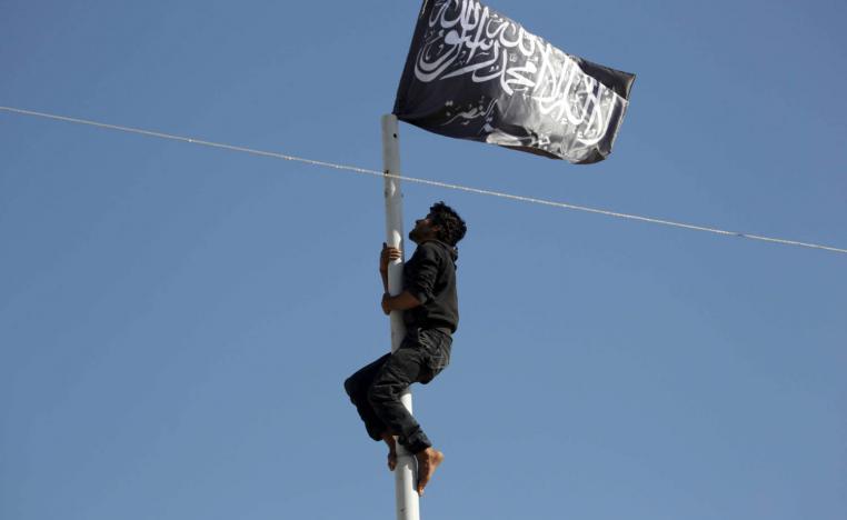 مقاتل من جبهة النصرة يرفع راية الجبهة على سارية في مدينة أريحا في محافظة إدلب