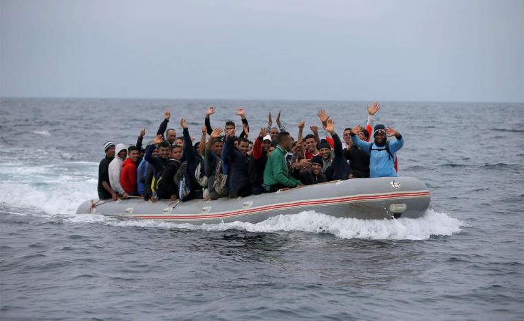 Migrants are seen on a dinghy as they cross the Strait of Gibraltar sailing from the coast of Morocco