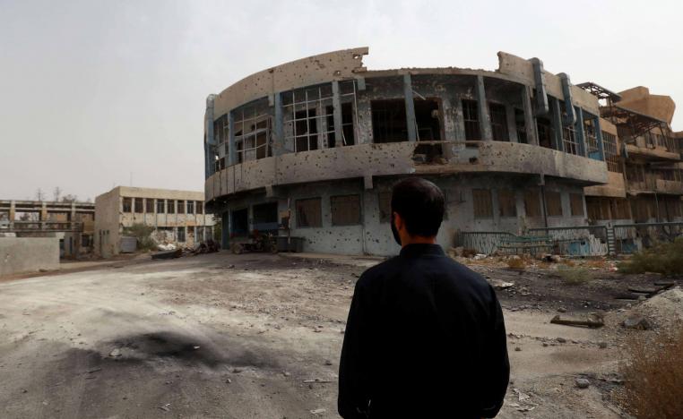 A member of the first response team tours the courtyard of the National Hospital building in the northern Syria city of Raqa