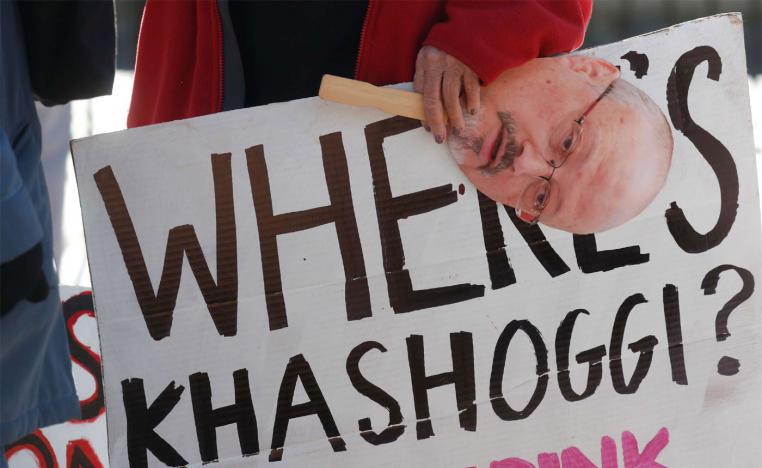 An activist holds a sign and image of missing Saudi journalist Jamal Khashoggi during a demonstration in Washington