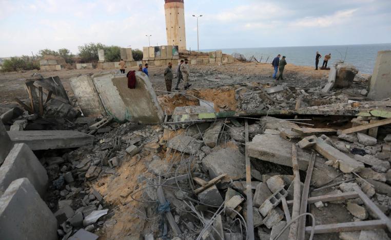 Palestinian men inspect the damage at a site targeted by an Israeli air strike.