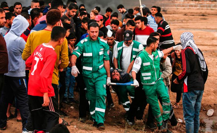 Palestinian paramedics carry away on a stretcher a protester who was injured during protests.
