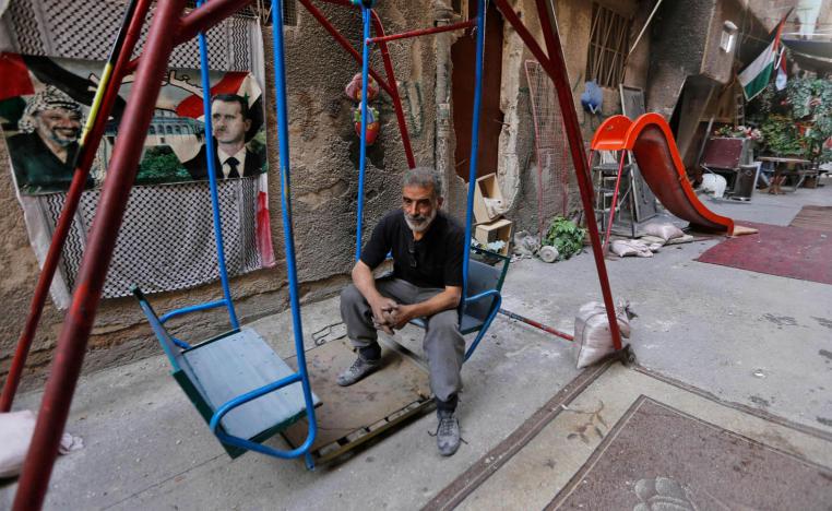 فلسطيني يجلس على أرجوحة في مخيم اليرموك بدمشق