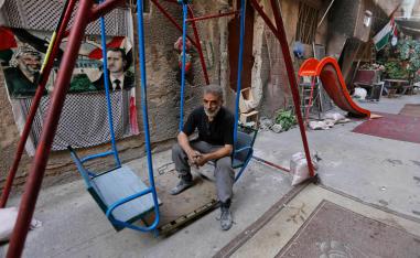 فلسطيني يجلس على أرجوحة في مخيم اليرموك بدمشق
