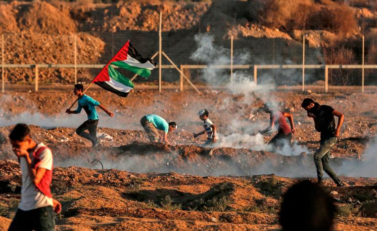 Palestinian protesters react to tear gas fired by Israeli forces during clashes east of Gaza City near the Israeli border on November 2, 2018.