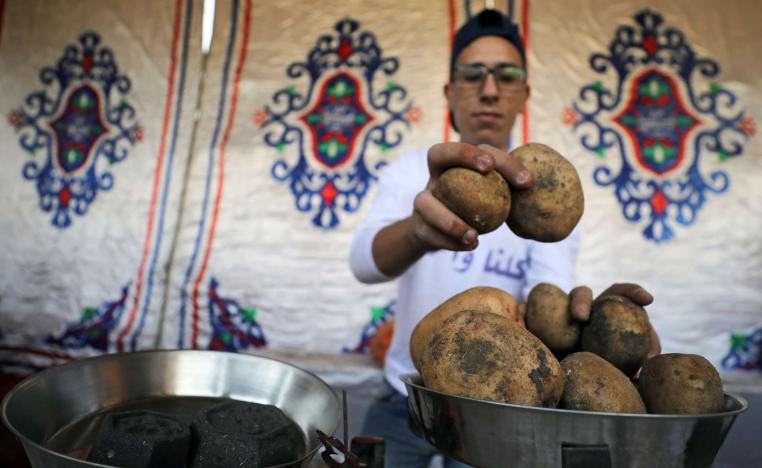 A vendor weighs potatoes at a temporary tent with government subsidised goods, after consumer prices increase across the country in Cairo, Egypt.