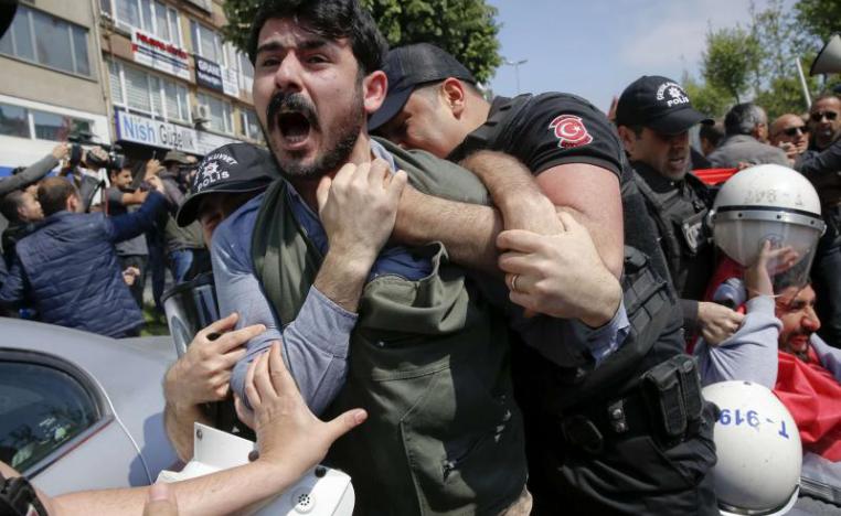 A demonstrator screams as police officers grab him during a protest in Istanbul