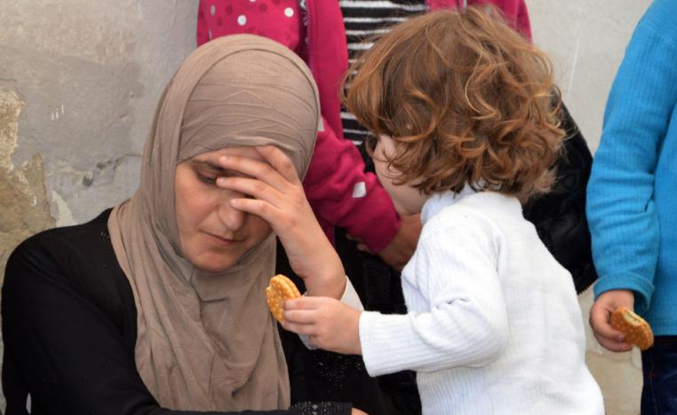A woman migrant and her child sit at the Tunisian port of Ben Guerdane, some 40km west of the Libyan border