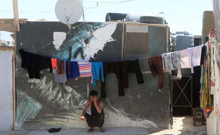 A young Syrian man sits outside a tent in a refugee camp on the outskirts of the town of Zahle in Lebanon's Bekaa Valley on June 23, 2018.