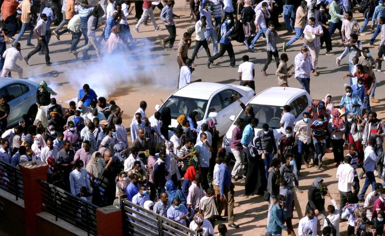 Sudanese demonstrators run from teargas lobbed to disperse them as they march along the street during anti-government protests in Khartoum, Sudan December 25, 2018. 