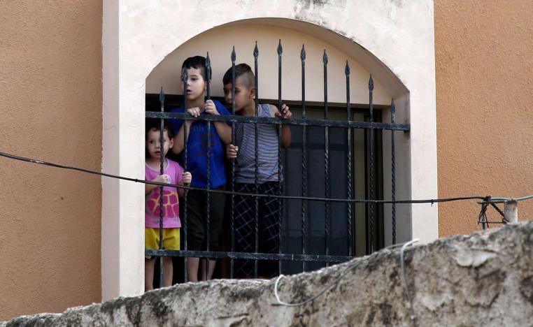 Palestinian children watch the funeral procession of 48-year-old mother of eight, Aisha Rabi, in the West Bank village of Bidya, near Salfit, on October 13, 2018..