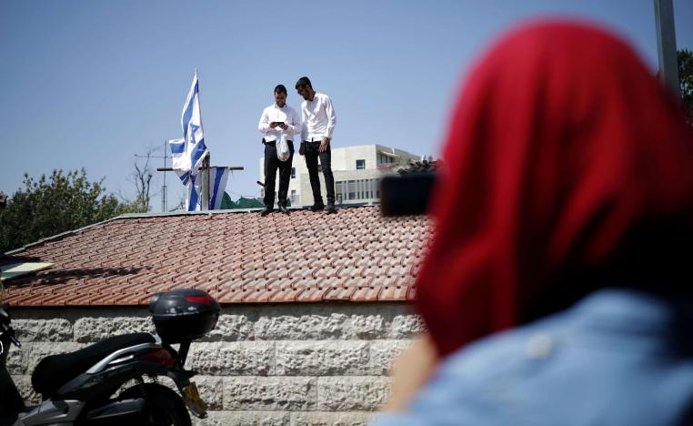 Religious Jewish men stand on the roof of a house seized by new Jewish owners in the Arab neighbourhood of Sheikh Jarrah in east Jerusalem on September 8, 2017, which originally belonged to the Palestinian Shamasneh family in which they lived for over half a century, until they were evicted on September 5.