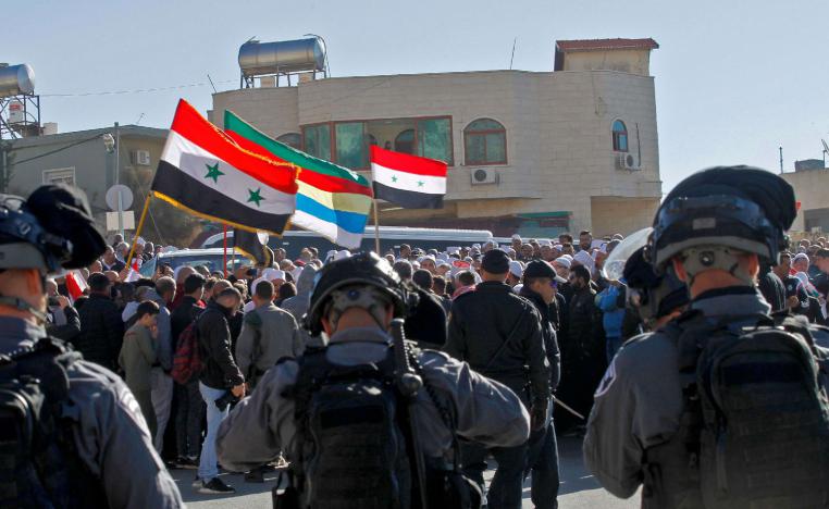 Israeli soldiers stand guard as Druze men protest against municipal elections in front of a polling centre in the village of Majdal Shams in the Israeli-occupied Golan Heights on October 30, 2018.